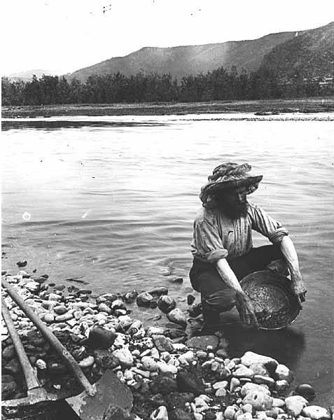 Archivo: Hombre con sombrero y mosquitero buscando oro en un arroyo, ubicación desconocida, alrededor de 1899 (WARNER 494).jpeg